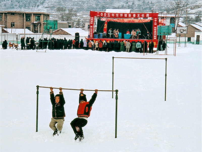 16、《鄉(xiāng)鎮(zhèn)文化周》2005年,淄博淄川東坪鄉(xiāng),每逢春節(jié)假日,淄博市三個(gè)劇團(tuán)都到鄉(xiāng)村進(jìn)行演出活動(dòng),這是市五音劇團(tuán)冒著大雪在東坪進(jìn)行演出,孩子們看不懂古裝戲,就在單杠上玩耍。(劉統(tǒng)愛(ài)).jpg